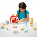 Meisje met bruin haar speelt met de Play-Doh Pizza Oven; rode oven, diverse accessoires, potjes Play-Doh.