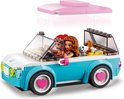 Twee LEGO Friends poppen rijden in een witte en turquoise cabriolet met roze hartvelgen. Een roze dak is bevestigd.