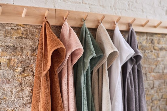 Zes badcapes in verschillende kleuren (bruin, roze, groen, beige, wit, grijs) hangen aan een houten rek.