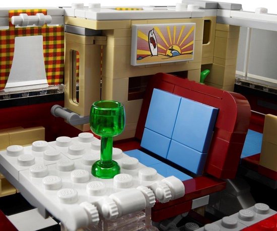 Interieur van een LEGO camper met tafel, groen glas, zitting en schilderij van een golf.