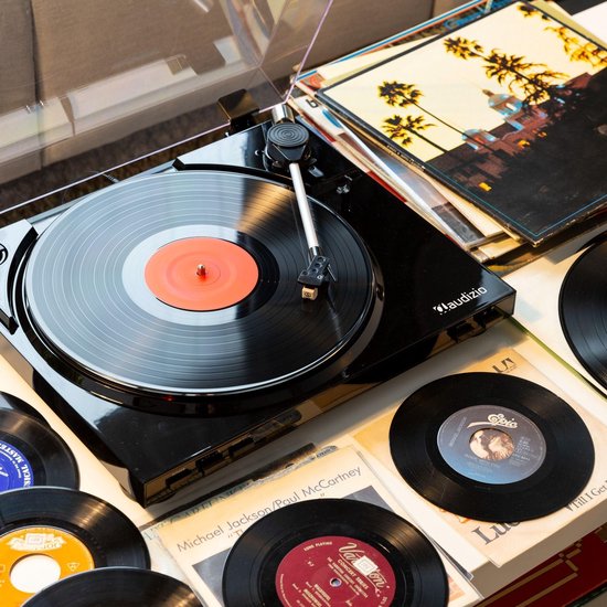 Zwarte Audizio platenspeler met vinylplaat en vele LP's eromheen.