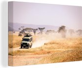 Canvas Schilderij Een safari-auto rijdt over de droge graslanden in Afrika - 90x60 cm - Wanddecoratie