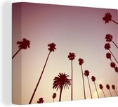 Canvas Schilderij De silhouetten van een rij met palmbomen voor een roze lucht - 120x90 cm - Wanddecoratie