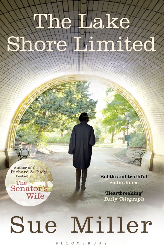 Boekomslag 'The Lake Shore Limited' van Sue Miller. Een vrouw in een lange jas en laarzen loopt weg onder een stenen boog naar een park.