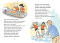 Twee meisjes in oranje shirts snijden een brood, een in het wit met een machine.