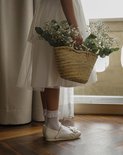 Meisjesbenen in witte sokken met kanten randje en roze schoentjes.