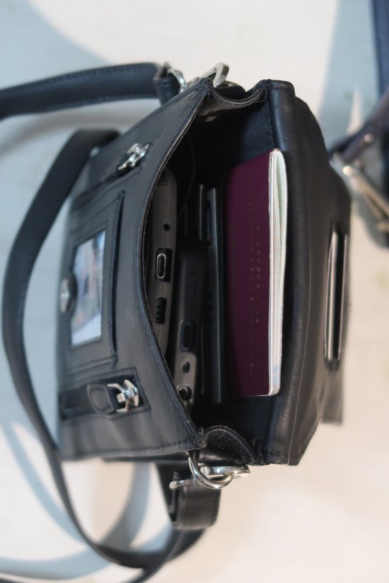 Zwarte leren tas, open met paspoort en telefoon erin.