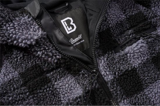 Gros plan sur la veste en polaire effet teddy avec fermeture éclair et le logo Brandit sur l'étiquette.
