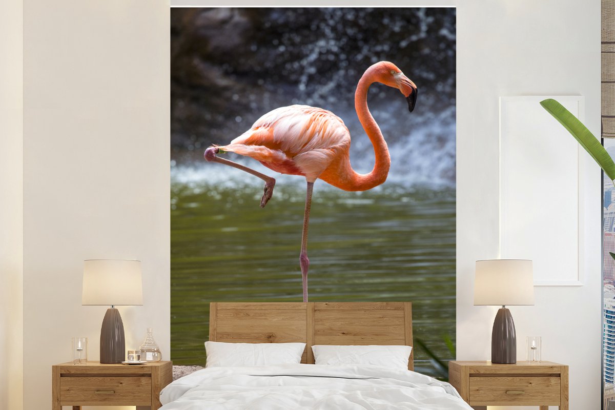 Behang - Fotobehang Een flamingo staat in het water - Breedte 155 cm x hoogte 240 cm