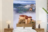 Behang - Fotobehang De Meteora kloosters tussen de wolken en uitzicht - Breedte 225 cm x hoogte 350 cm