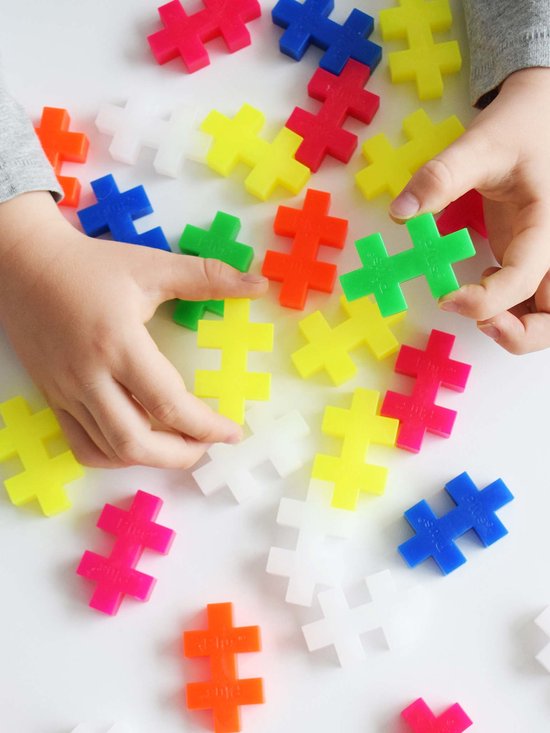 Kinderhandjes sorteren en spelen met Plus-Plus BIG bouwstenen in levendige kleuren zoals roze, oranje, geel, groen, blauw en wit.