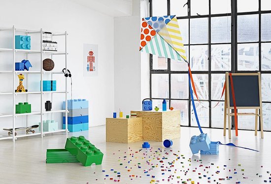 Kinderkamer met witte rekken gevuld met Lego-opbergdozen en speelgoed, inclusief een kite.