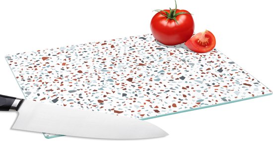 Planche à découper en verre motif terrazzo gris, bleu, marron sur fond blanc.
