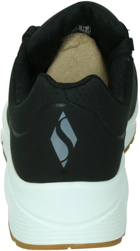 Achterkant van zwarte Skechers Uno sneaker met witte zool en bruine rand.