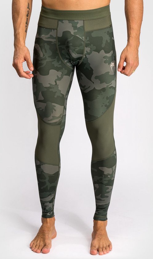 Legging met camouflageprint in legergroen en grijs. Met gaasdetails aan de zijkant en een logo op het linkerbeen. Gedragen door een man.
