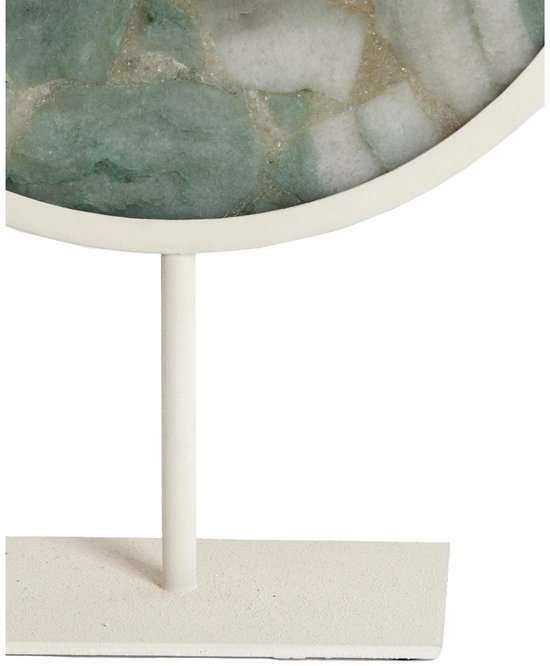 Onderkant van een ronde, lichtgroene steen met witte aders op een witte standaard.