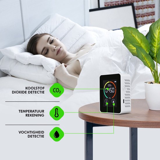 Vrouw slaapt in bed, naast een CO2-meter die CO2, temperatuur en vochtigheid meet.