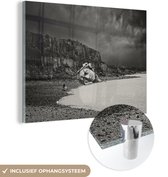 MuchoWow® Glasschilderij 160x120 cm - Schilderij acrylglas - Meisje is alleen op de wereld op strand met hoofd van beeld in zwart-wit - Foto op glas - Schilderijen