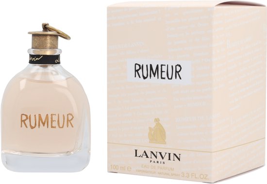 Glazen parfumflesje met gouden letters "RUMEUR" naast een crèmekleurige verpakking met "RUMEUR".