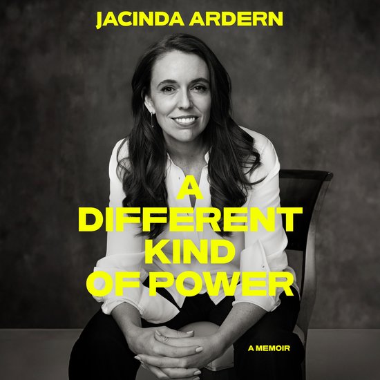 Jacinda Ardern est assise sur une chaise, portant une blouse blanche et un pantalon noir. Le texte 'A Different Kind of Power' est sur l'image.