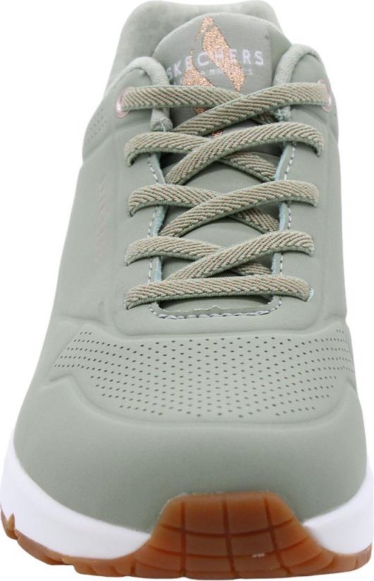 Voorkant van een lichtgroene Skechers sneaker met perforaties op de neus en koperkleurige details.