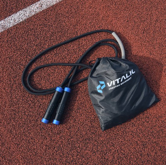 Zwart springtouw met blauwe handvatten en een zwarte draagtas op een atletiekbaan.