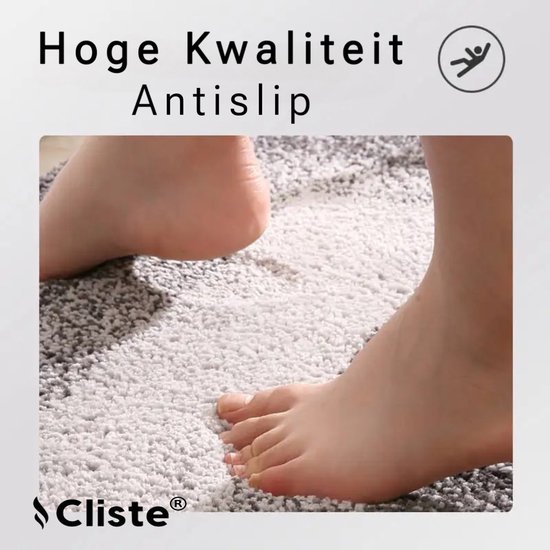 Close-up van voeten op een zachte, grijze en witte badmat. Hoge kwaliteit, antislip.