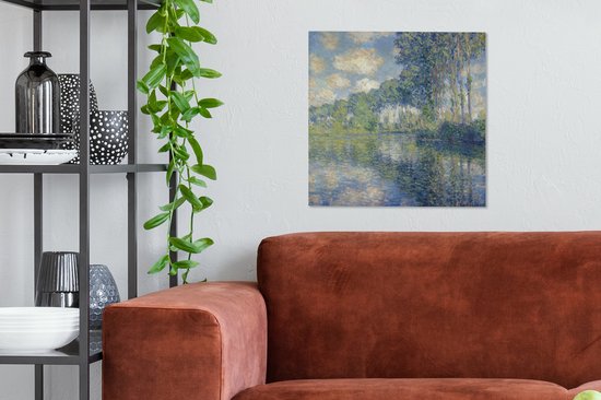 Tableau de Claude Monet: Peuples au bord de l'Epte, suspendu dans une pièce avec un canapé orange et une étagère.