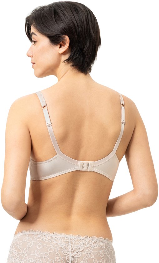 Modèle vu de dos, portant un soutien-gorge armatures beige et une culotte assortie à détails en dentelle.