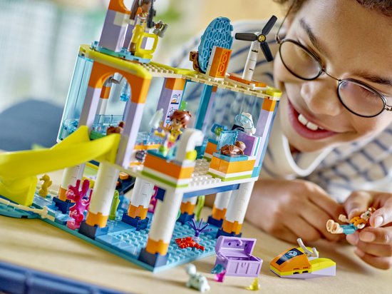 Kind speelt met het LEGO Friends Reddingscentrum op zee. Met gebouw, glijbaan, poppetjes en speelgoeddieren.