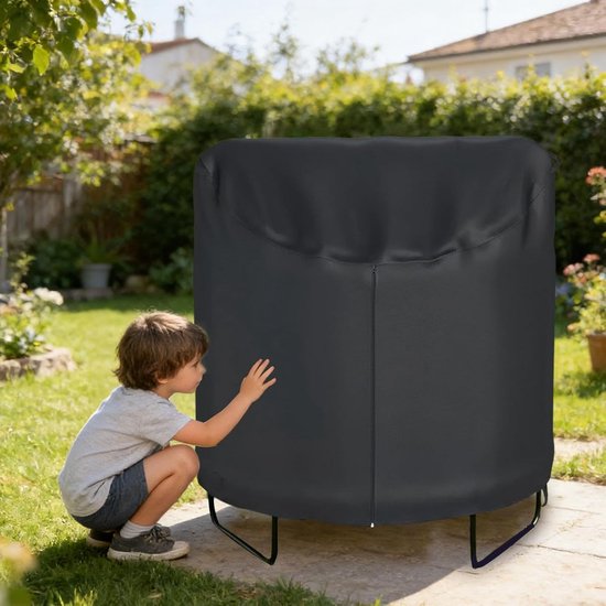 Zwarte trampolinehoes met rits in een achtertuin, een jongen raakt de hoes aan.