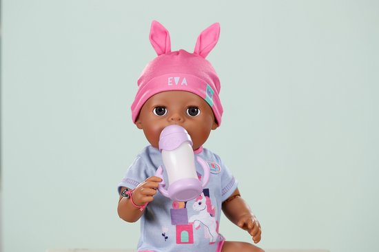 BABY born pop Eva drinkt uit paarse fles, draagt blauw romper met eenhoorn en roze konijnenmuts.