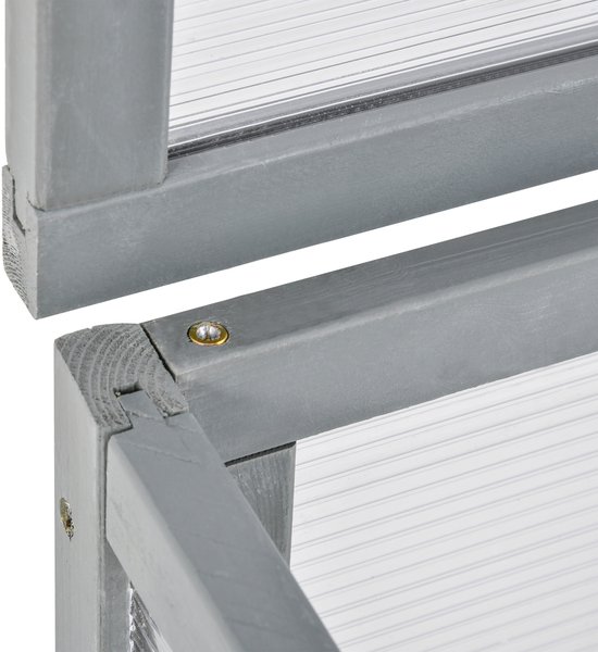 Gedetailleerde hoekverbinding van de grijze houten kas met transparante panelen.