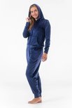 Donkerblauwe fluwelen joggingbroek met capuchon en rits, gedragen door een vrouw.