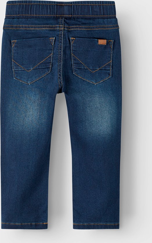 Donkerblauwe spijkerbroek met stonewashed effect, trekkoord en oranje stiksels. Twee achterzakken met oranje V-stiksels.