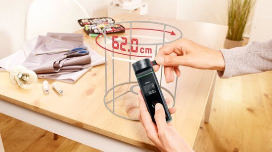 Bosch Zamo afstandsmeter met lintadapter meet de omtrek van een metalen cirkel, 62.0 cm wordt weergegeven.