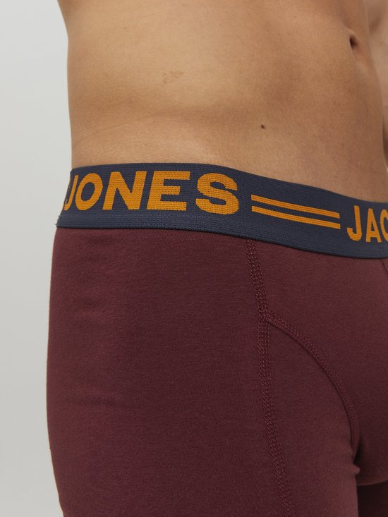 Close-up van een donkerrode boxer met een donkerblauwe elastische band met oranje tekst: JACK & JONES.