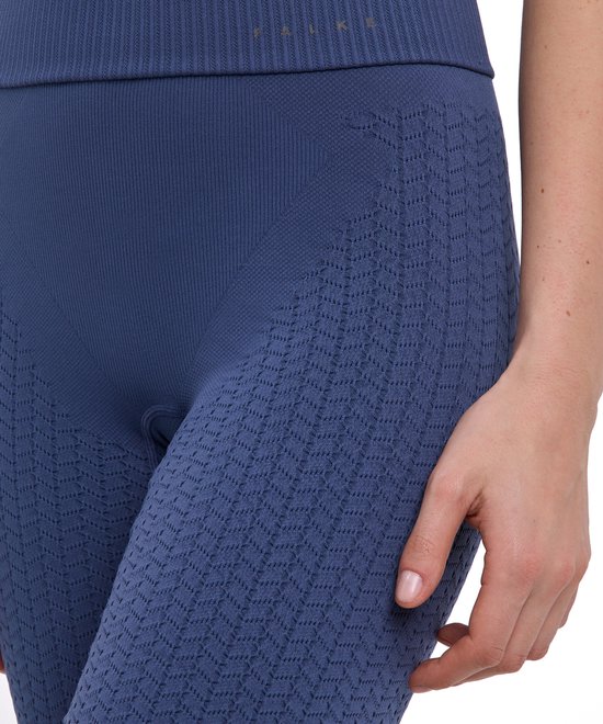 Close-up van blauwe, nauwsluitende sportlegging met textuurpatroon en hoge geribbelde tailleband.