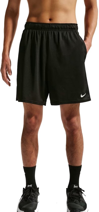 Man draagt zwarte Nike trainingsshort met witte swoosh.