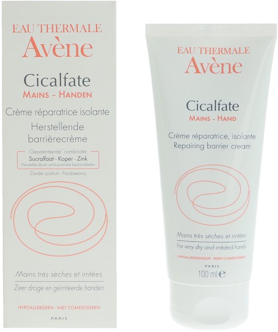 Witte kartonnen verpakking en tube voor Avène Cicalfate Handcrème. Tekst in het Frans en Engels, met roze cirkelvormig logo en tekst 'Mains très sèches et irritées'.