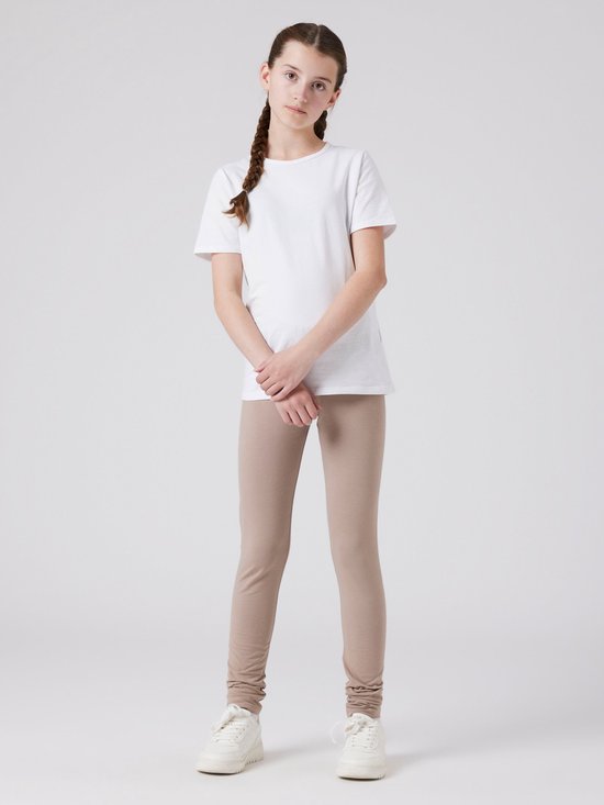 Meisje met een witte T-shirt en taupe legging.