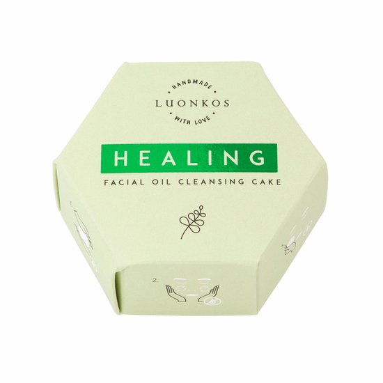 Lichtgroene verpakking in zeshoekige vorm met tekst 'HEALING FACIAL OIL CLEANSING CAKE'.