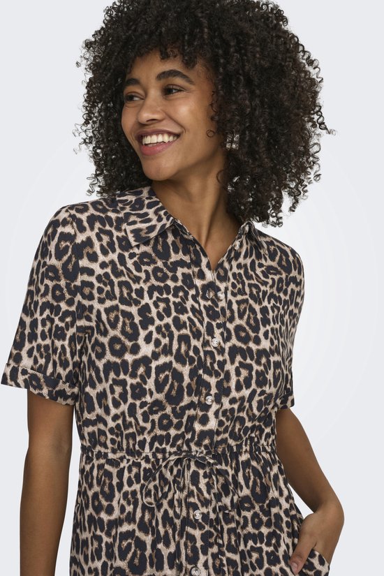 Close-up van een dame in een jurk met luipaardprint, korte mouwen, strikceintuur en kraagje.