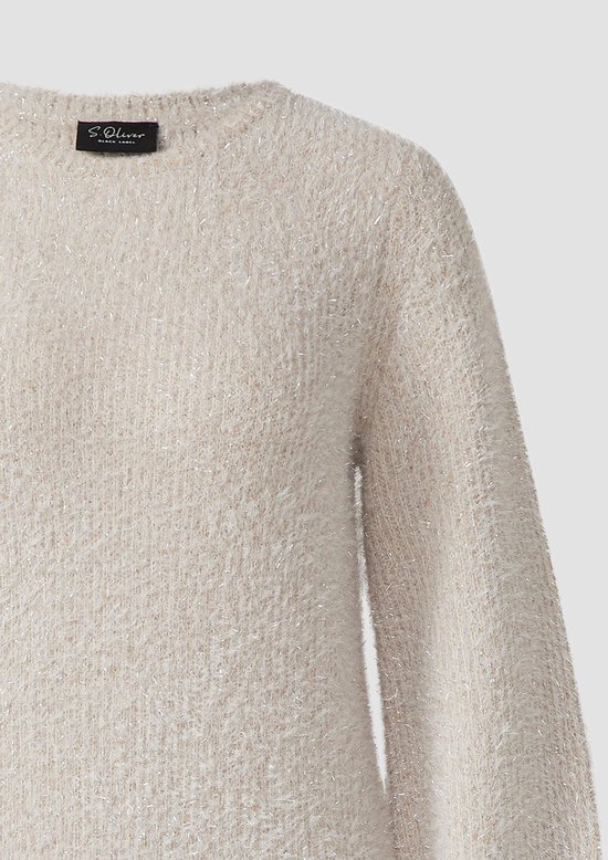 Close-up van de beige gebreide stof met glitters van een jurk.