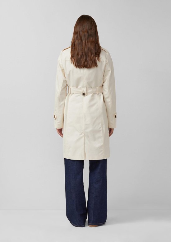 Crèmekleurige trenchcoat met ceintuur, gedragen met spijkerbroek. Achteraanzicht.