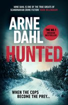 Boekomslag: Arne Dahl Hunted. Sneeuw, bos en een besneeuwde weg. Tekst: 'Arne Dahl is een van de ware grootheden van de Scandinavische misdaadfictie' - Mark Billingham. 'The No.1 Swedish Bestseller'. 'When the cops become the prey...'