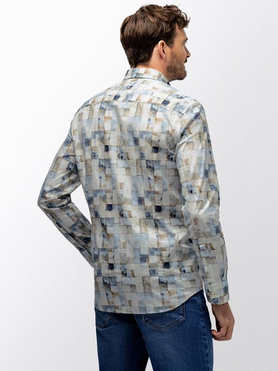 Man draagt een langarmig overhemd met mozaïekprint van beige, blauwe en witte vierkanten, gezien vanaf de achterkant.