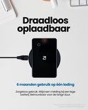 Zwarte tracker wordt draadloos opgeladen op een zwarte oplader.