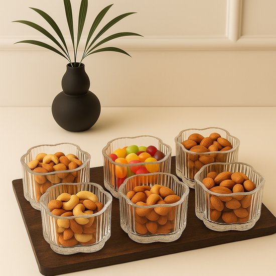 Set de six petits bols à tapas en verre côtelé, remplis de noix de cajou, d'amandes et de bonbons colorés.