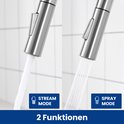 Zilverkleurige keukenkraan in de modus 'stream' en 'spray', beide met water uit de sproeier.